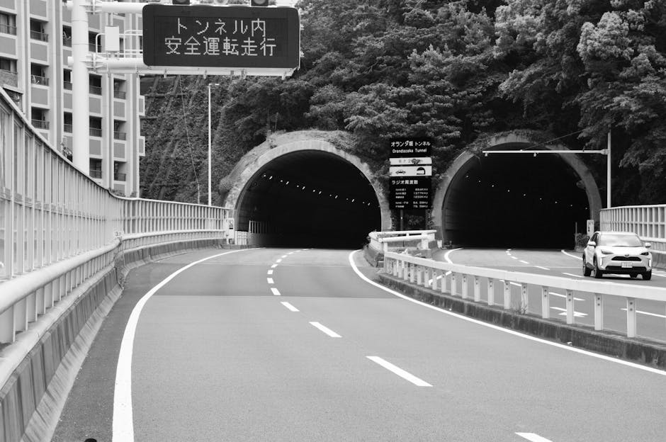 Black and white image of Onaribashi Tunnel with deserted road and modern SUV.